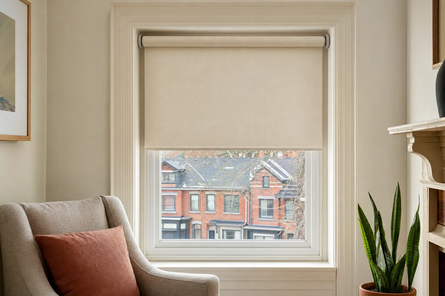 A cream roller blind tension-fitted inside a deep painted window recess, its round end caps pressing against the two sides with no brackets, screws or holes in the trim