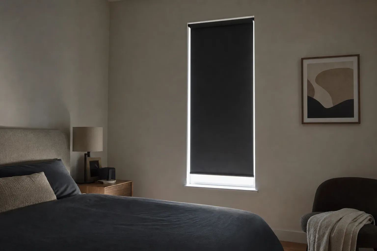 Narrow bedroom window with a dark blackout roller lowered and bright daylight outlining both side edges